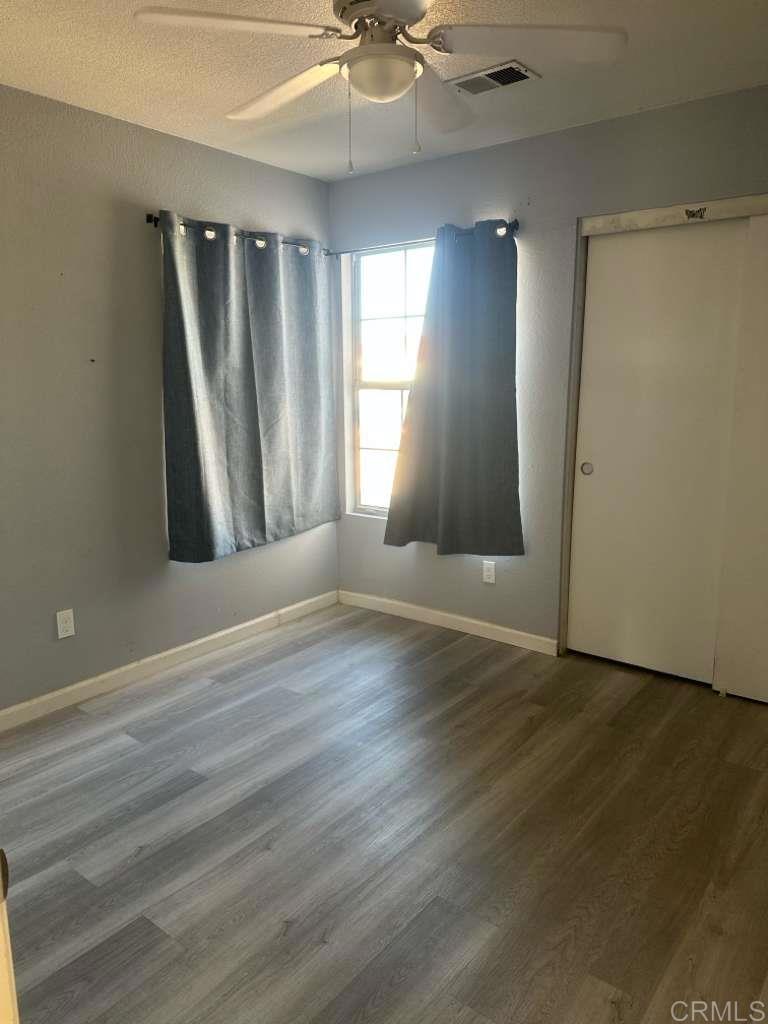 952 Alameda Street Calexico, CA 92231 - Photo 4 of 7 an empty room with wooden floor and windows