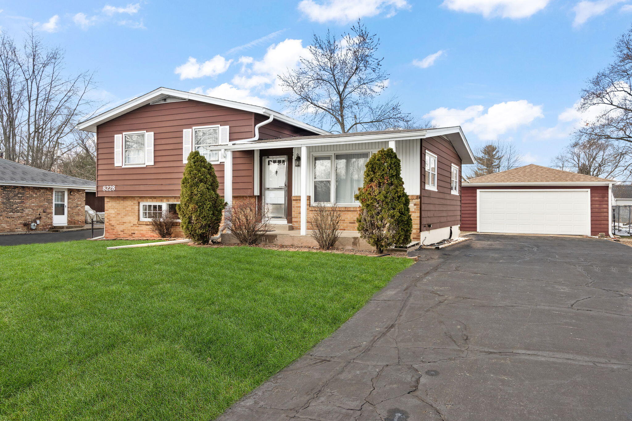 8228 Rutledge Street Merrillville, IN 46410 - Photo 1 of 32 a front view of a house with a yard and garage