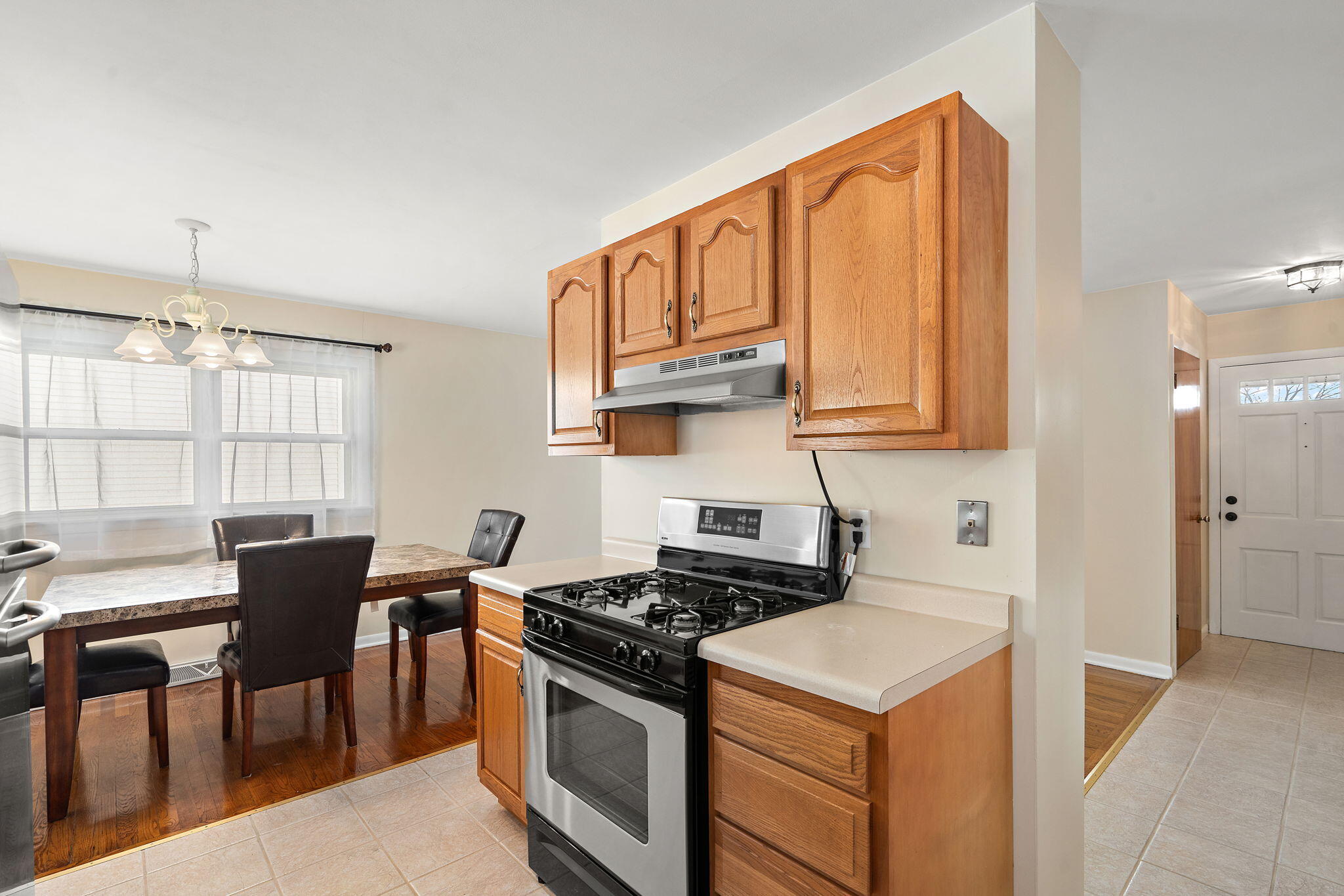8228 Rutledge Street Merrillville, IN 46410 - Photo 12 of 32 a kitchen with stainless steel appliances granite countertop a stove a sink and a microwave