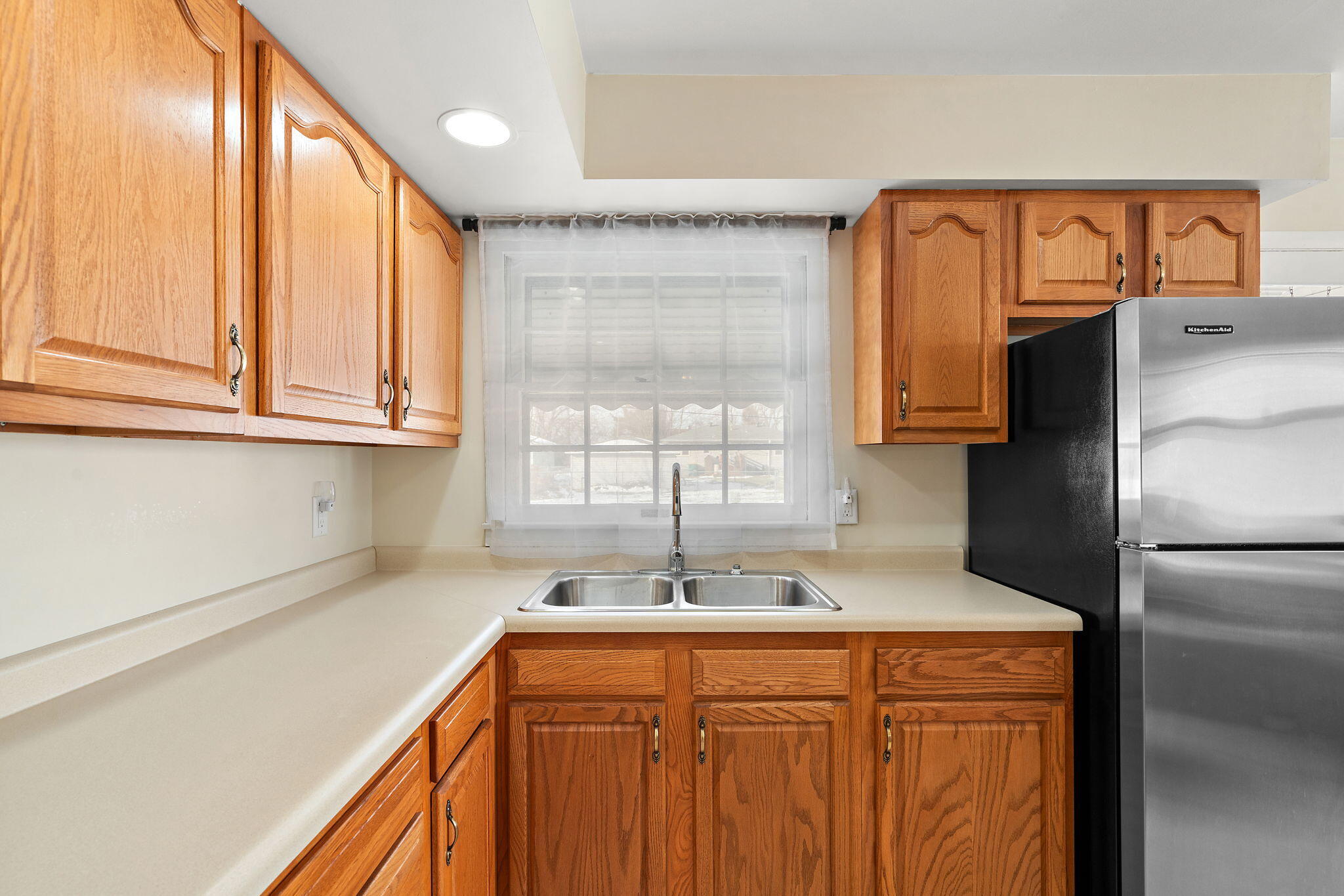 8228 Rutledge Street Merrillville, IN 46410 - Photo 13 of 32 a kitchen with stainless steel appliances granite countertop a sink and a refrigerator