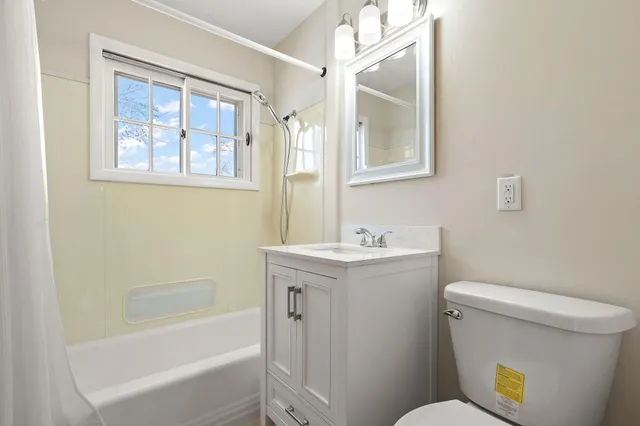 a bathroom with a sink and mirror with toilet
