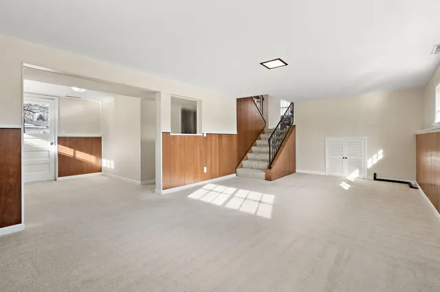 a view of a livingroom and a hall with wooden floor