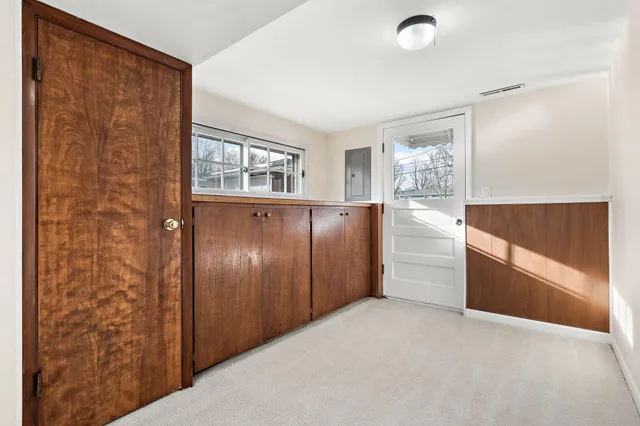 a view of hallway with window and wooden floor