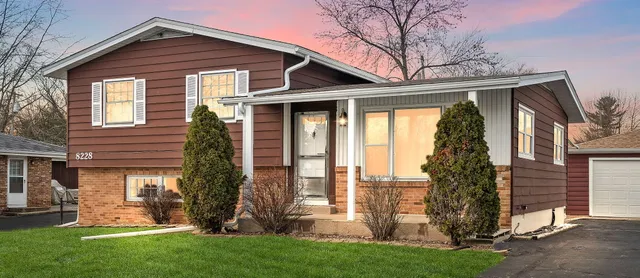 a front view of house with a garden
