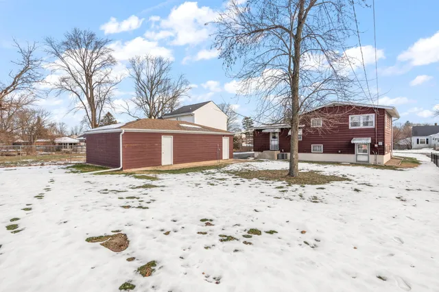 a front view of a house with a yard covered in snow