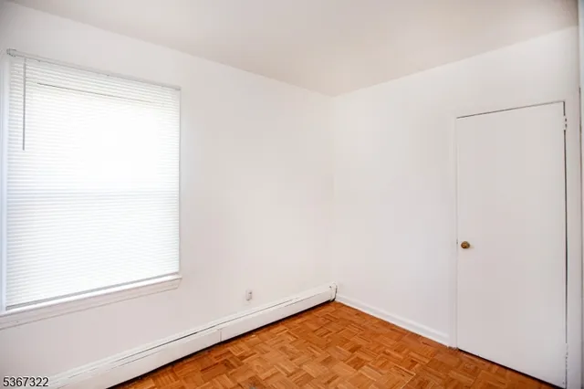 a view of a room with wooden floor and a window