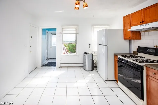a kitchen with a stove a refrigerator and cabinets
