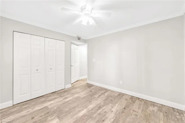 an empty room with a ceiling fan and a window