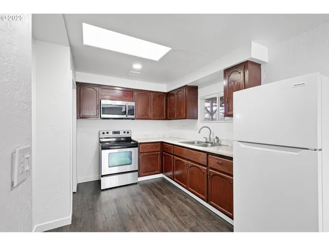 a kitchen with stainless steel appliances granite countertop a sink stove and microwave