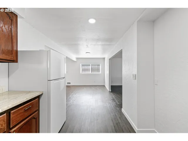 a view of an empty room with wooden floor and closet