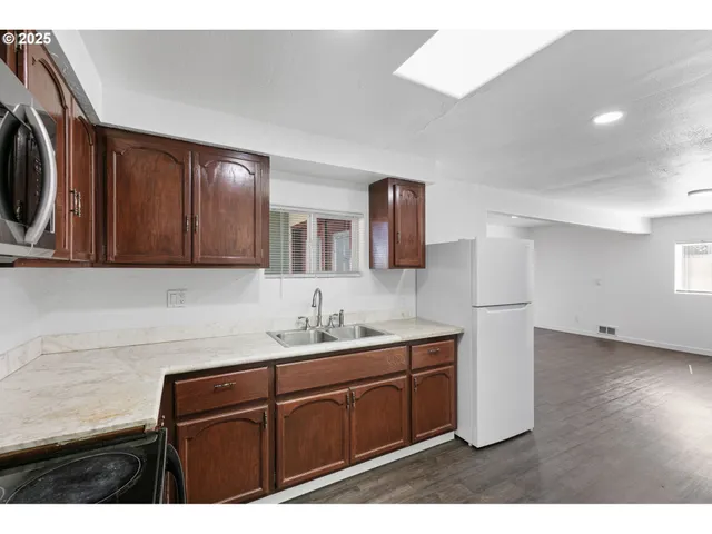 an aerial view of residential houses with outdoor space and trees