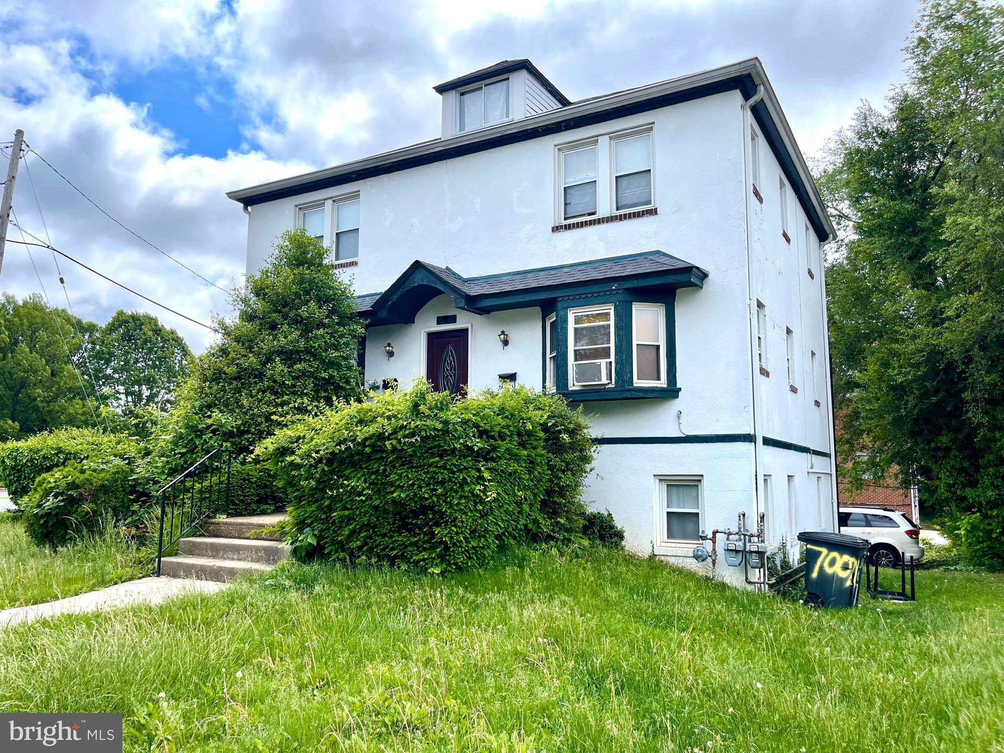 700 Charing Cross Road Baltimore, MD 21229 - Photo 2 of 7 a view of a white house next to a yard with plants and trees