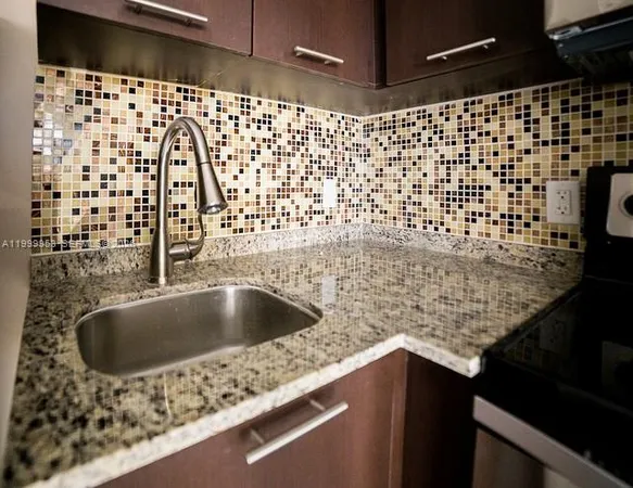 a view of a sink and dishwasher with wooden floor
