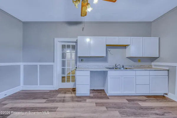 a kitchen with a sink cabinets and a wooden floor