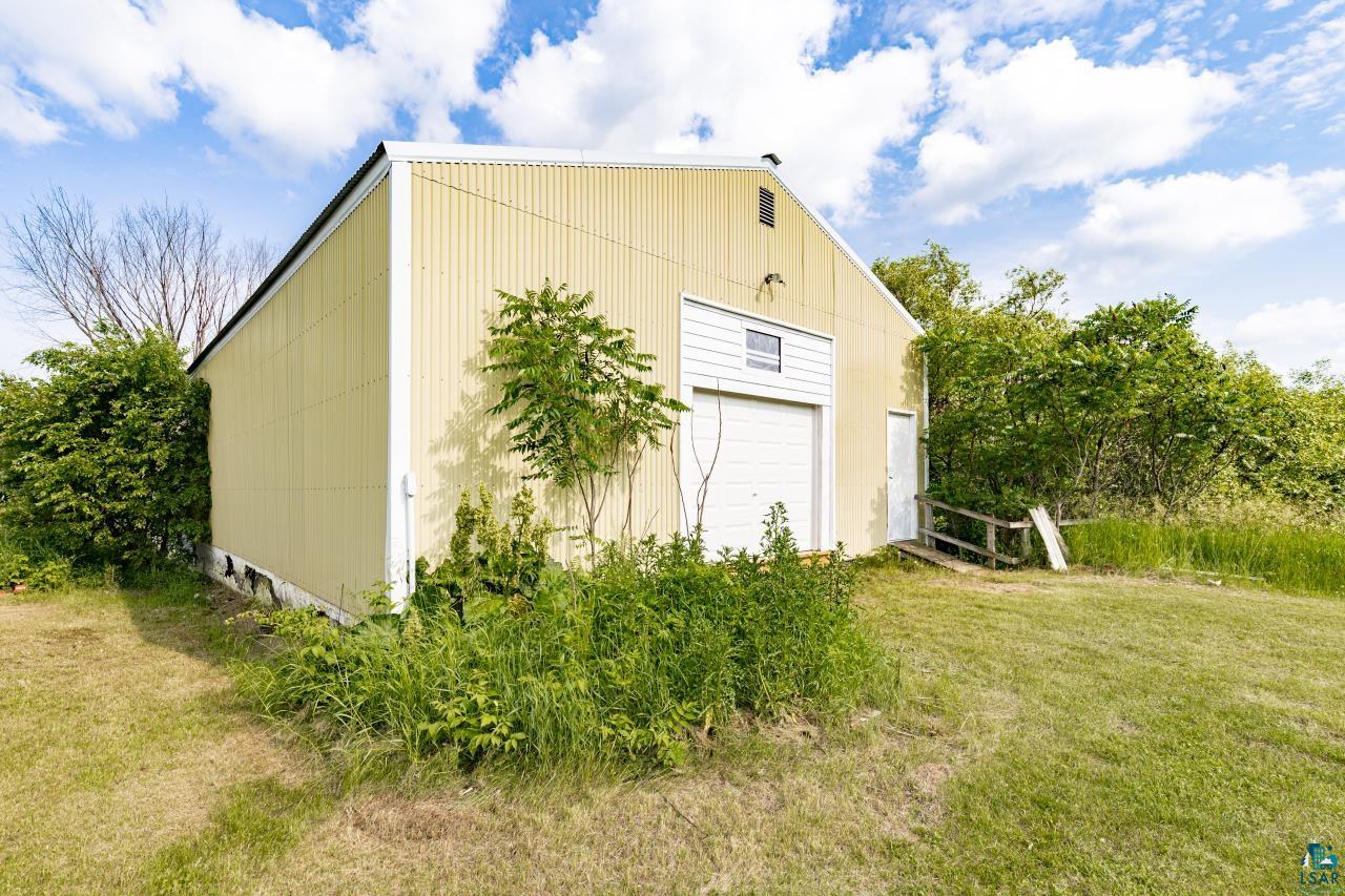 4800 Tower Road Moose Lake, MN 55767 - Photo 78 of 83 Freestanding utility building featuring a corrugated metal exterior, a white overhead door, and a separate pedestrian entry with a ramp