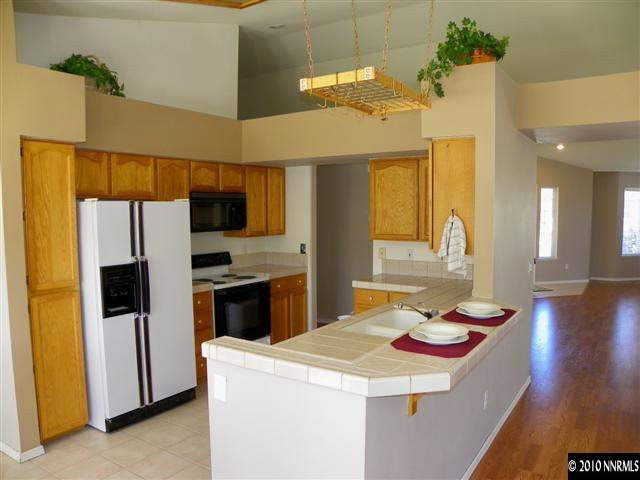 5860 Simons Drive Reno, NV 89523 - Photo 4 of 9 a kitchen that has a kitchen island wooden cabinets and stainless steel appliances