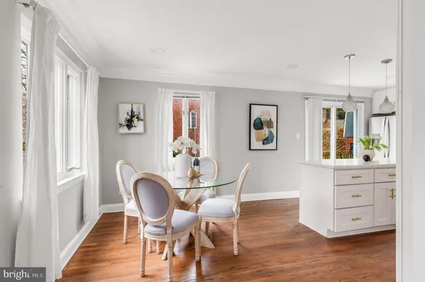 a view of a dining room with furniture large windows and wooden floor