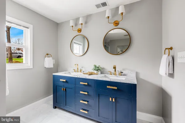 a bathroom with a double vanity sink mirror and shower