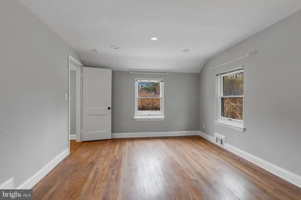 a view of a hallway with wooden floor and entryway
