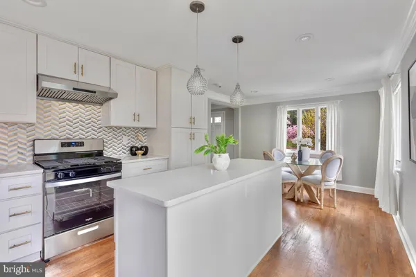 a living room with stainless steel appliances kitchen island furniture and wooden floor