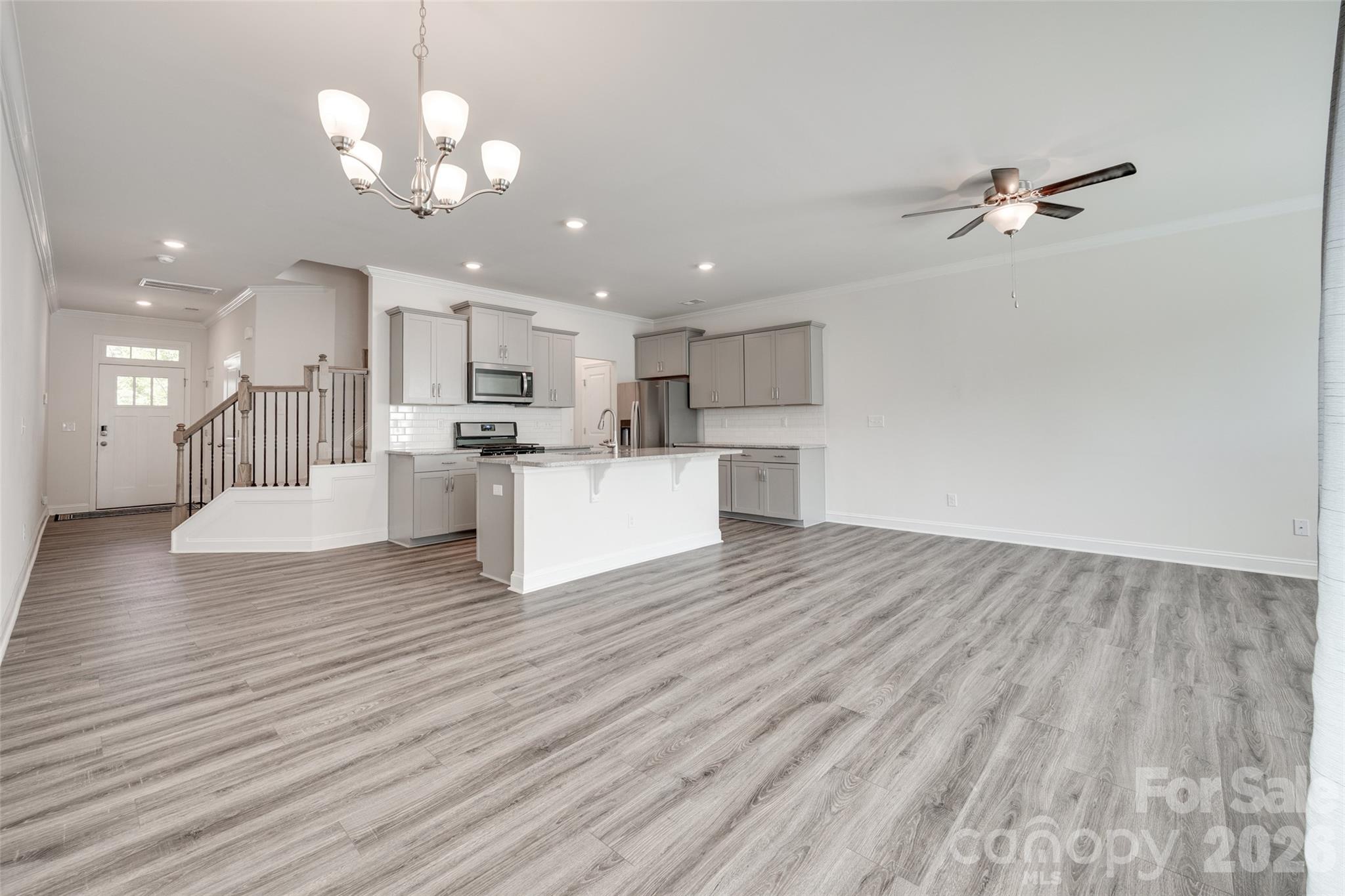 642 Altamonte Drive Clover, SC 29710 - Photo 29 of 41 a view of a kitchen with a sink dishwasher a kitchen island wooden floor and a chandelier