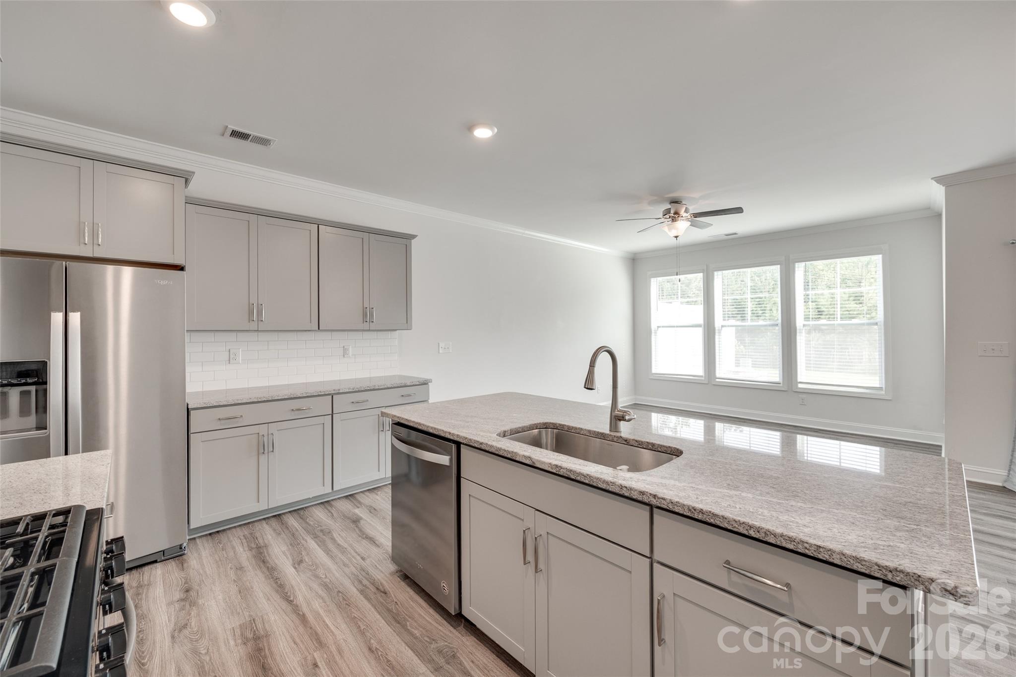 642 Altamonte Drive Clover, SC 29710 - Photo 33 of 41 a kitchen with a sink dishwasher a refrigerator with white cabinets and wooden floor