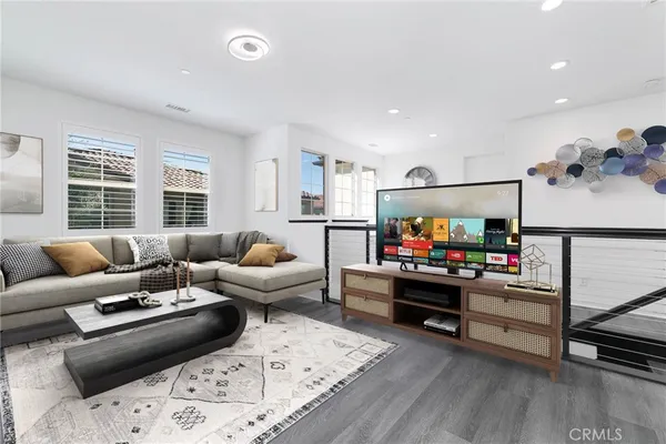 a view of an empty room with wooden floor and windows