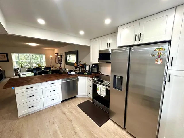 a kitchen with stainless steel appliances a refrigerator sink and microwave