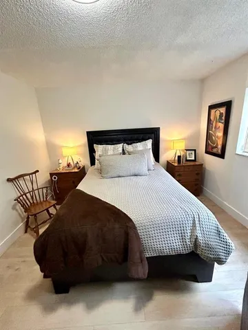 a bedroom with a bed and wooden floor