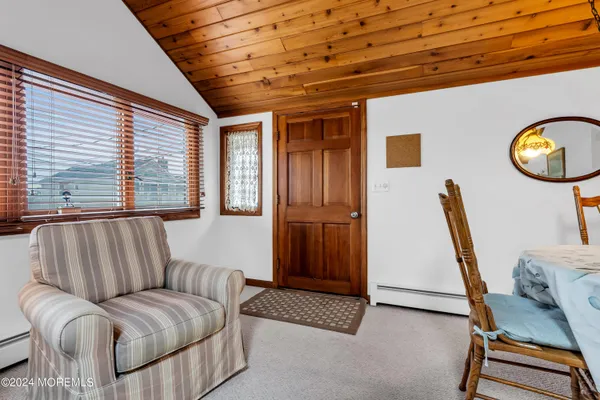 a living room with furniture a air conditioner vent and a window