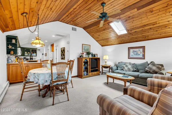 a living room with furniture kitchen view and a chandelier