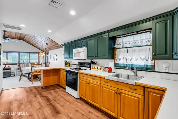 a large kitchen with stainless steel appliances granite countertop a sink and cabinets