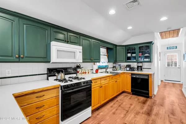 a kitchen with stainless steel appliances granite countertop a stove a sink and a microwave