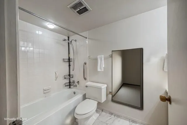 a bathroom with a shower a toilet and a tub