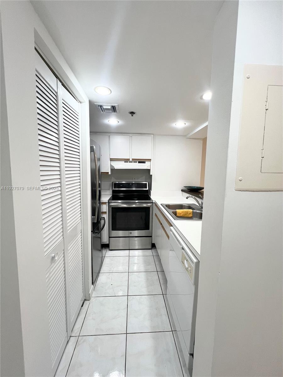 540 Brickell Key Drive, Unit 214 Miami, FL 33131 - Photo 18 of 48 a kitchen with stainless steel appliances a refrigerator and a stove top oven