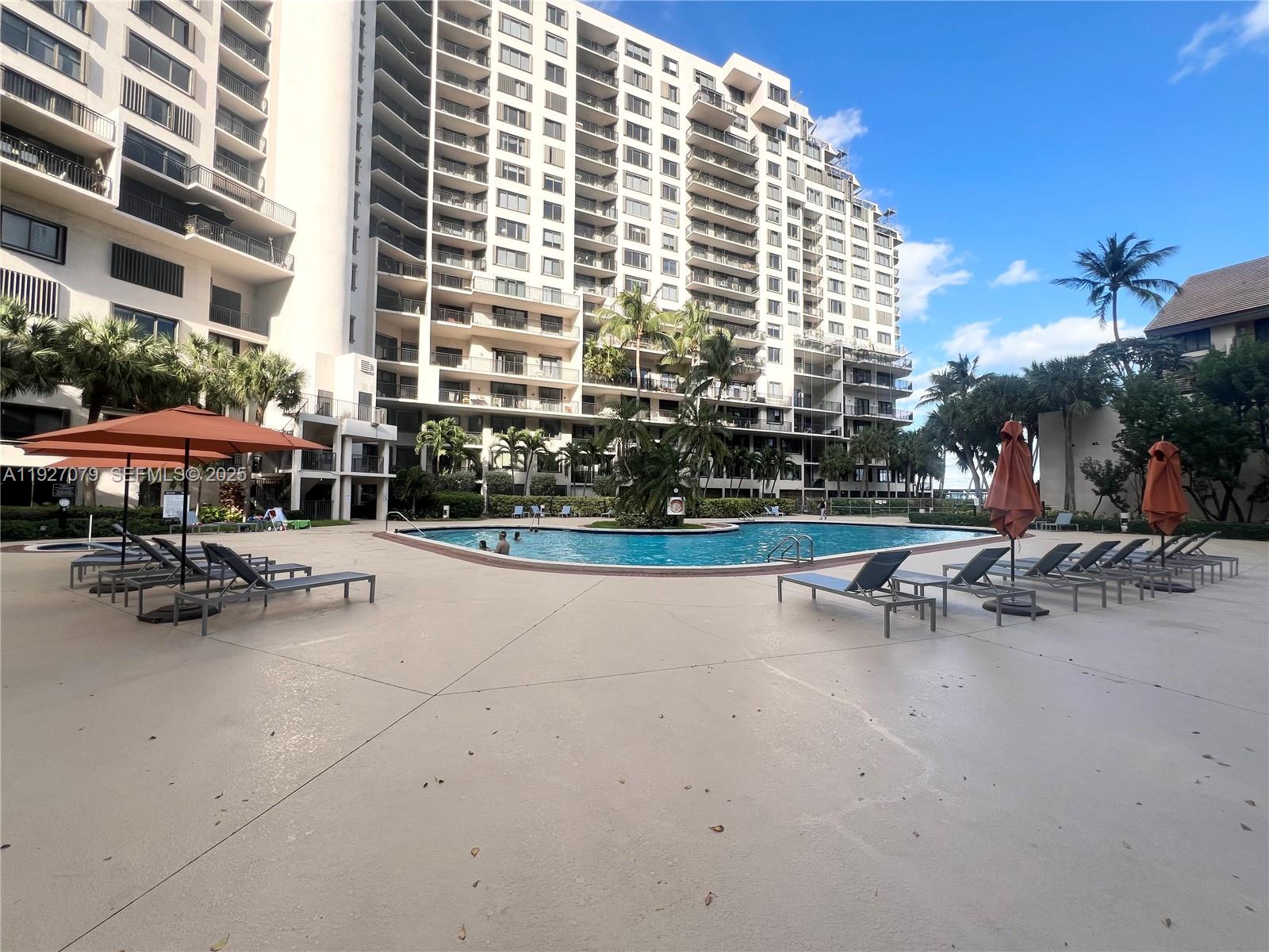 540 Brickell Key Drive, Unit 214 Miami, FL 33131 - Photo 36 of 48 a view of a patio with a table and chairs under an umbrella