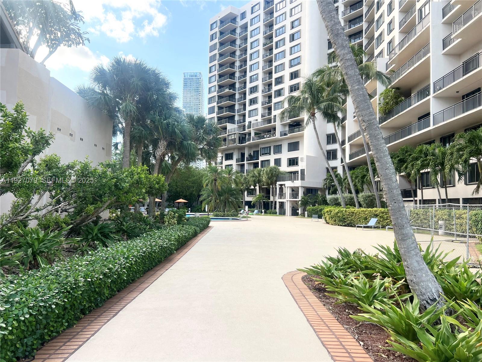 540 Brickell Key Drive, Unit 214 Miami, FL 33131 - Photo 45 of 48 a front view of a multi story residential apartment building with yard and green space