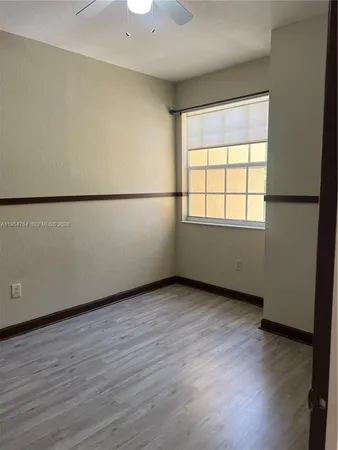 an empty room with wooden floor and cabinet