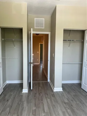 a view of a room with wooden floor and a window