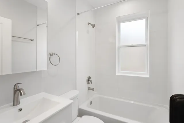 a bathroom with a tub shower vanity and a sink