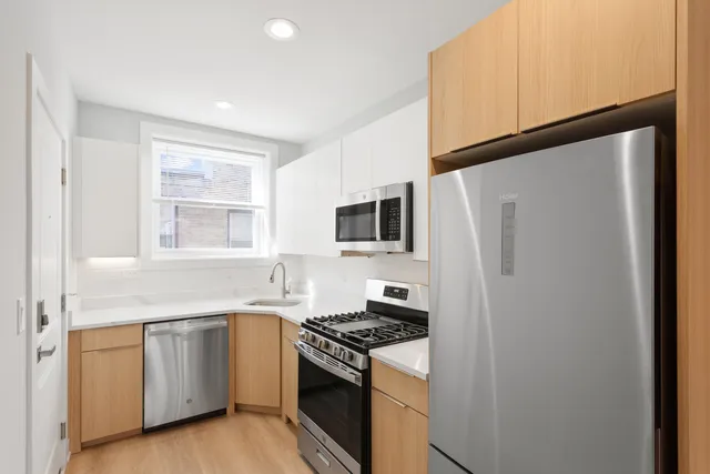a kitchen with white cabinets and white appliances