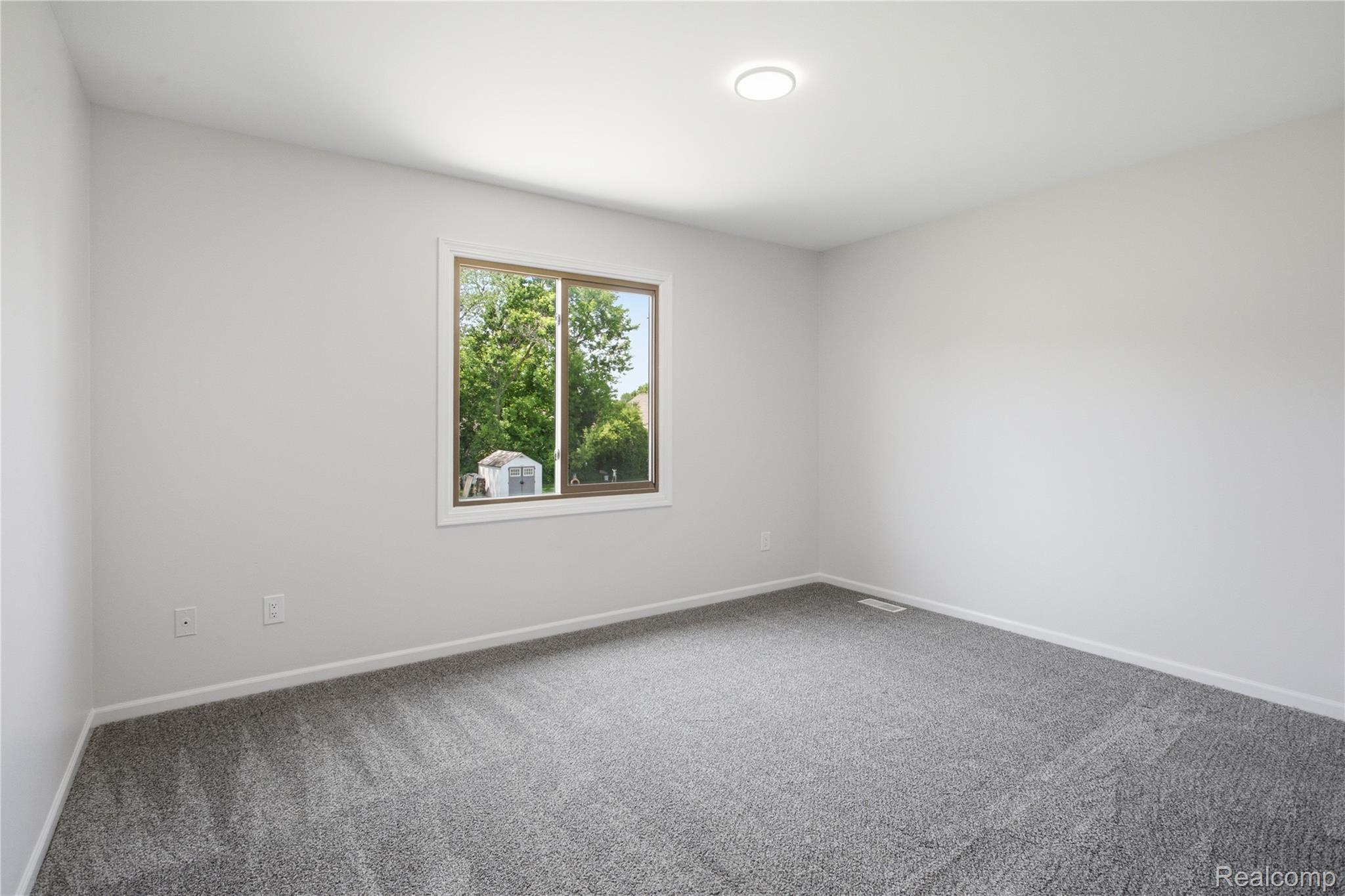 52658 Stag Ridge Drive Macomb, MI 48042 - Photo 26 of 28 Spacious room featuring gray wall-to-wall carpeting, white baseboards, and neutral-toned walls