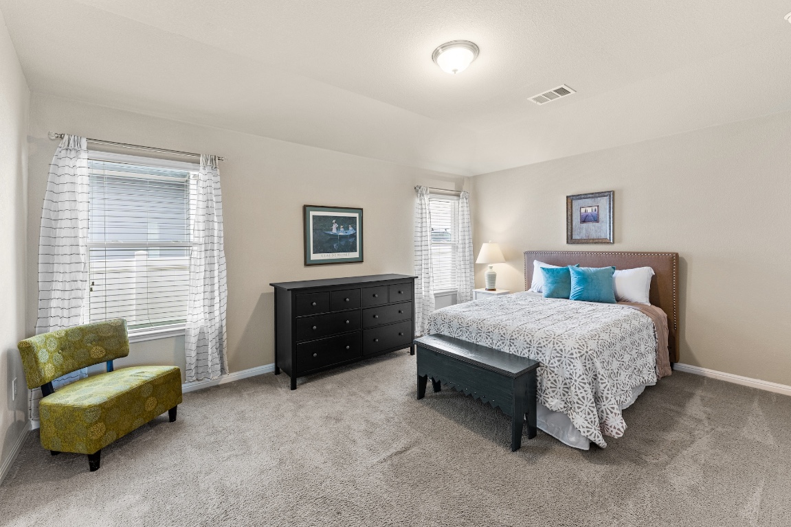 408 Cane River Road Pflugerville, TX 78660 - Photo 15 of 38 a spacious bedroom with a bed and a couch