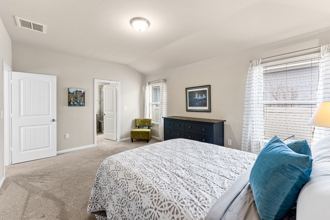 408 Cane River Road Pflugerville, TX 78660 - Photo 16 of 38 a bed sitting in a bedroom and a chandelier