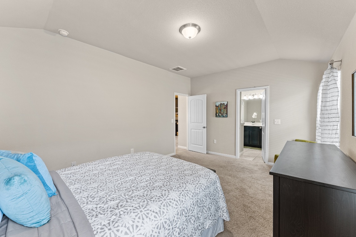 408 Cane River Road Pflugerville, TX 78660 - Photo 17 of 38 a bedroom with a bed and wooden floor