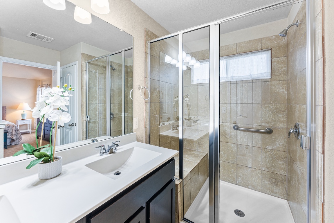 408 Cane River Road Pflugerville, TX 78660 - Photo 20 of 38 a bathroom with a shower sink and mirror