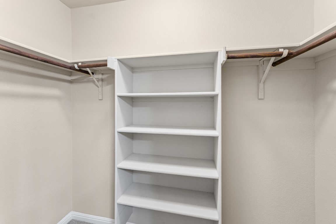 408 Cane River Road Pflugerville, TX 78660 - Photo 21 of 38 a view of walk in closet with empty racks