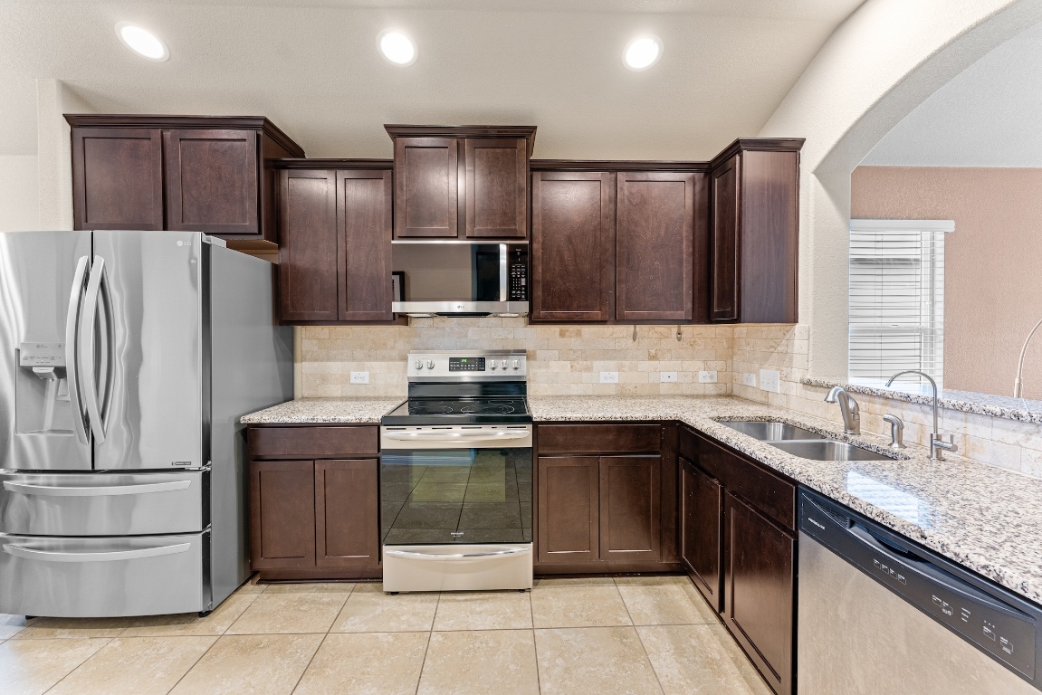 408 Cane River Road Pflugerville, TX 78660 - Photo 5 of 38 a kitchen with stainless steel appliances and refrigerator