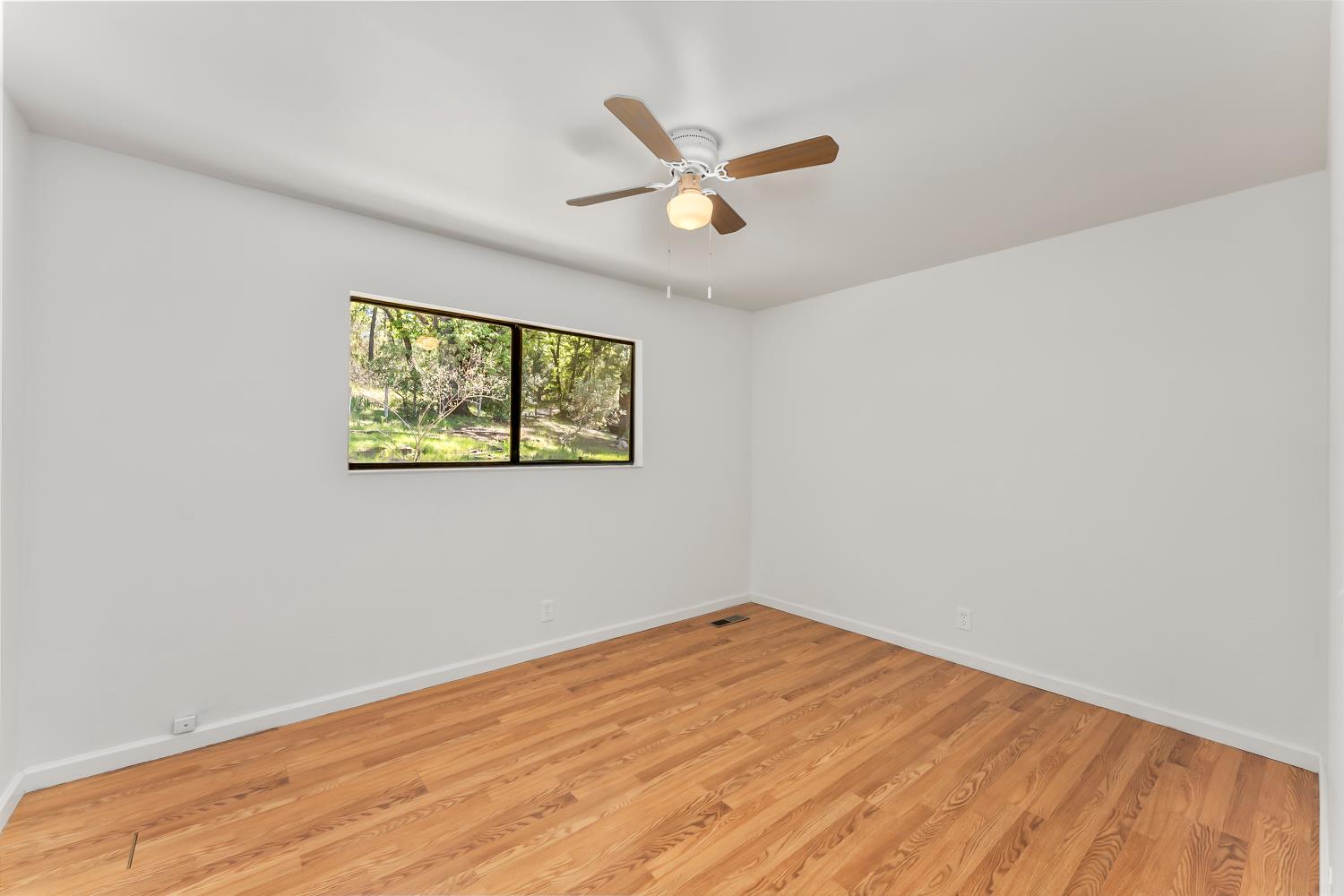 4705 Sand Ridge Road Placerville, CA 95667 - Photo 19 of 36 a view of empty room with wooden floor and ceiling fan