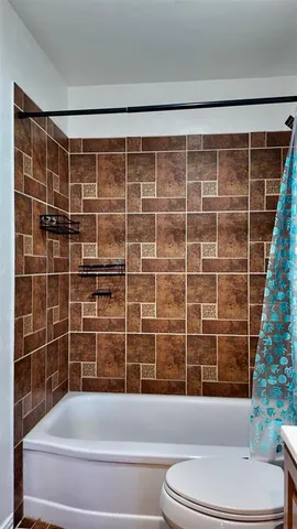 a bathroom with toilet shower and bathtub